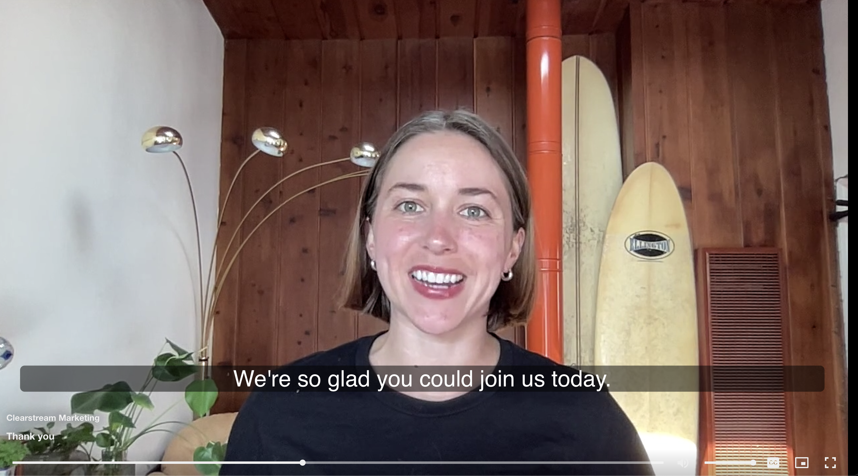 A video of a young smiling woman, with closed captions reading 'We're so glad you could join us today."